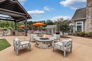 An outdoor patio with a fire pit and tables